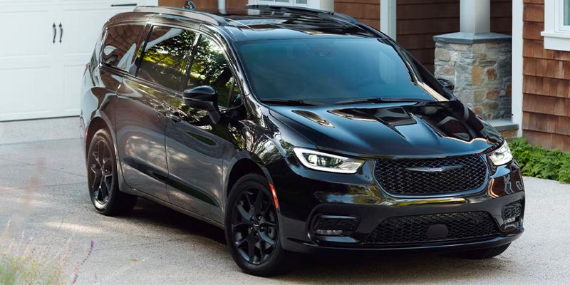 Shiny black minivan with black trim parked in a Pacifica driveway