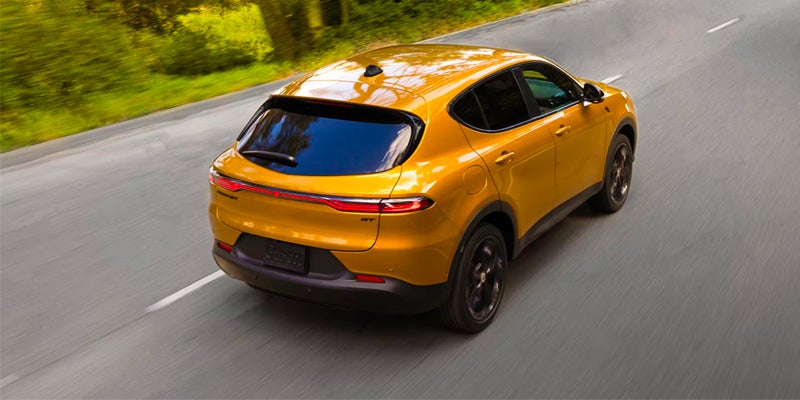 Yellow Dodge Hornet GT compact SUV driving on a winding road